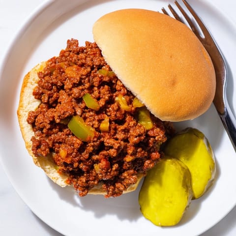 Mounded ground beef filling with onions and peppers in a tangy sauce on soft buns.