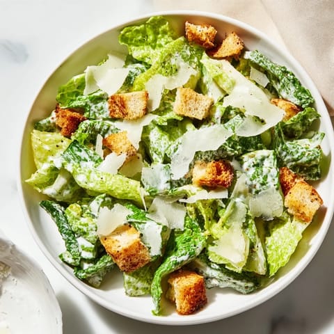Homemade Caesar Salad featuring crunchy croutons and grated Parmesan cheese on a rustic wooden table.