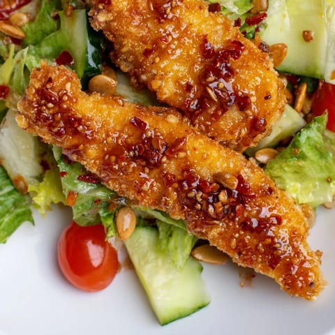 Crispy Hot Honey Chicken Salad features crunchy panko-coated chicken and a bold hot honey glaze on fresh greens.  