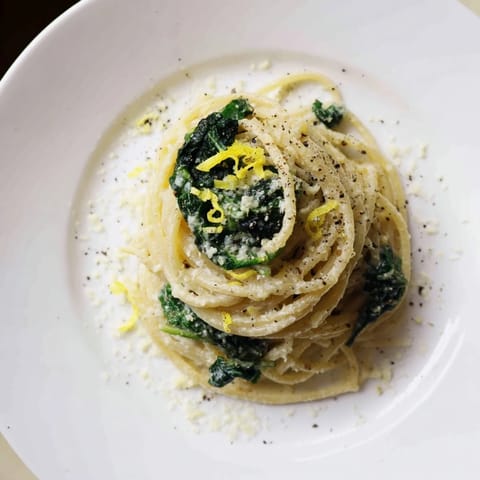 Creamy Lemon Spinach Spaghetti twirls in a glossy lemon cream sauce, served hot with fresh grated Parmesan and extra zest.