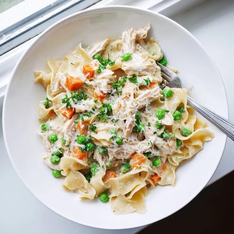 Spring Chicken Noodle Skillet with tender shredded chicken, egg noodles, peas, and carrots in a creamy sauce.  