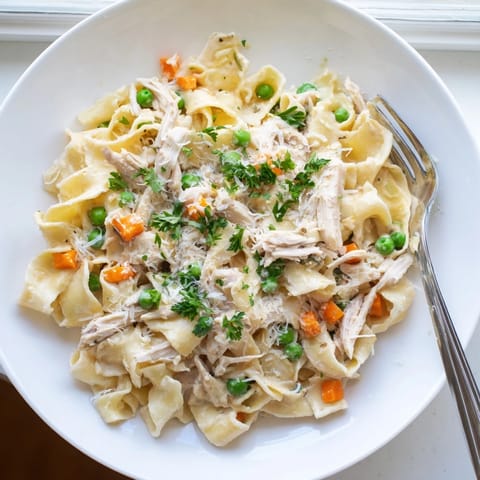 A comforting Spring Chicken Noodle Skillet served warm, garnished with fresh parsley and Parmesan.  