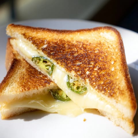 Golden, crispy sourdough slices encase melted Havarti cheese and fresh jalapeño slices, a delicious vegetarian sandwich.  