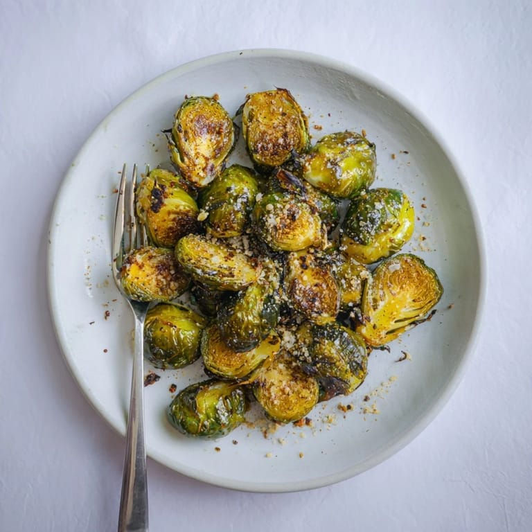Whole roasted Brussels sprouts roasted to golden perfection arranged on a warm plate, highlighting their caramelized edges as a delicious gluten-free side dish for dinner.