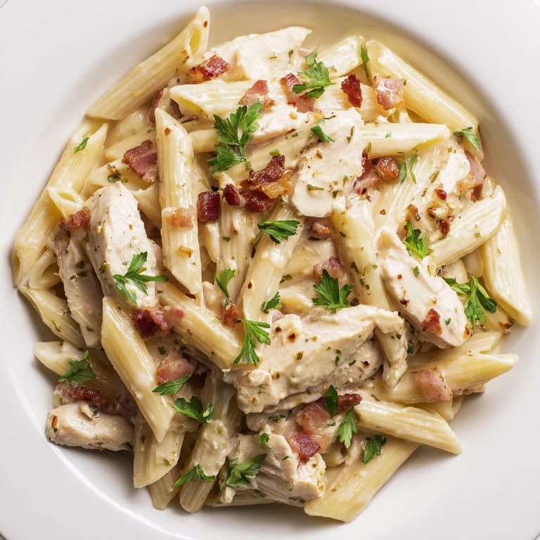 Overhead view of Creamy Chicken Bacon Penne in a rustic bowl, featuring al dente penne tossed in creamy sauce, perfect for a comforting weeknight dinner.