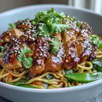Vibrant Sesame Chicken Noodle Bowl with crisp bell peppers and tender chicken tossed in a sweet-savory sauce.