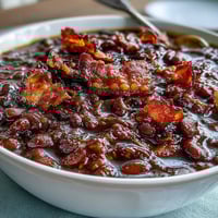 1. A hearty skillet of summer BBQ baked beans with brown sugar and bacon, bubbling in a smoky, sweet sauce with crispy bacon bits.  