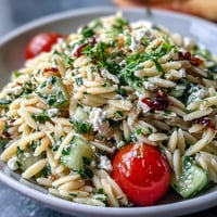 Orzo salad with cucumber, feta, and lemon dressing, bursting with fresh Mediterranean flavors.